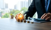 Businessman using calculator with glowing dollar plant icons above growing coin stacks, symbolizing financial growth and investment planning.