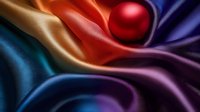 Vibrant silk fabric waves in rainbow colors with red sphere creating elegant folds and shadows, abstract luxury background for fashion and design projects.