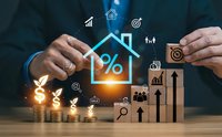 Businessman hands protecting house with percentage symbol and financial icons representing mortgage rates, real estate investment and property loans.