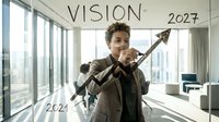 Young mixed-race businessman drawing upward arrow from 2024 to Vision 2027 on glass in modern office with city view for strategic planning presentations.