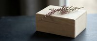 Elegant wooden jewelry box with intricate floral engraving on lid, natural wood grain texture, perfect for luxury storage and organization solutions.