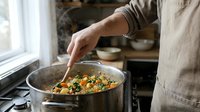 Person cooking healthy vegetable stir-fry in kitchen pan with wooden spoon, preparing nutritious meal at home stove for dinner preparation and culinary lifestyle.