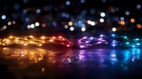 Colorful LED string lights with rainbow spectrum creating magical bokeh effect on dark surface for holiday decorations and festive celebrations.