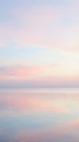 Serene dawn seascape with soft pastel sky reflecting on calm ocean waters, capturing peaceful morning atmosphere for wellness and nature projects.