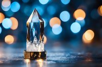 Clear quartz crystal point with golden base on wooden surface against colorful bokeh lights background for meditation and spiritual healing practices.