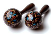 Wooden maracas with traditional folk art painting featuring floral patterns in blue and gold on dark brown background, isolated on white for music design.