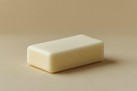 White bar of soap on beige background with soft shadow, minimalist composition showing personal hygiene product for bathroom and skincare routines.