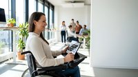 Professional businesswoman using tablet in modern office workspace with colleagues collaborating in background for corporate presentations and meetings.