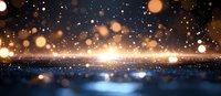 Magical glowing bokeh lights on dark blue background with golden sparkles and shimmering particles creating dreamy atmospheric effect.