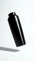 Black metallic water bottle with screw cap tilted at angle against white background, casting shadow. Suitable for beverage, lifestyle, and product mockup applications.