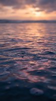 Dreamy ocean waves at sunset with soft pink and purple sky reflections creating peaceful seascape atmosphere for meditation and wellness content.