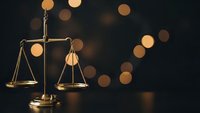 Golden scales of justice with warm bokeh lights creating elegant legal concept for law firm branding and courtroom presentations.