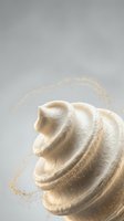 Swirled whipped cream topped with golden glitter dust on a soft gray background, evoking luxury dessert and gourmet food styling.