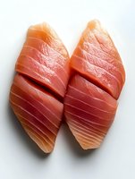 Pair of fresh salmon fillets with vibrant orange-red flesh and delicate texture, isolated on white background for culinary and food styling use.