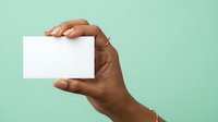 Hand holding blank white card against mint green background, ready for business branding, marketing mockup, or corporate identity design.