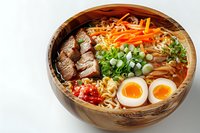 Asian noodle soup with sliced beef, soft-boiled egg, carrots, green onions and spicy broth served in wooden bowl on white background.