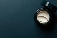 Luxury face cream jar with golden spatula on dark blue background, premium skincare product for anti-aging and moisturizing routines.