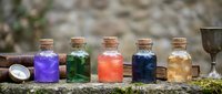 Colorful magical potion bottles with cork stoppers arranged on stone surface. Fantasy alchemy ingredients in glass vials for witchcraft and mystical brewing concepts.