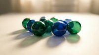 Colorful glass marbles in green and blue scattered on wooden surface with soft lighting creating shadows for games and childhood memories.
