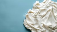 Fluffy white meringue peaks swirled against turquoise background, creating soft texture and contrast for food photography and dessert marketing.