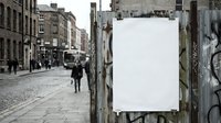 Blank white poster mockup on urban street with cobblestone pavement and historic buildings. Empty billboard template for advertising campaigns and marketing.