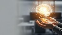 Hands holding glowing brain with sparkling lights representing artificial intelligence, innovation, creativity and mental power in modern office setting.