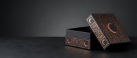Ornate wooden jewelry box with intricate carved patterns and metal accents on dark surface, luxury storage container for precious items and accessories.