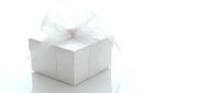 White gift box with elegant sheer ribbon bow on bright background, perfect for holiday, wedding, and celebration concepts.