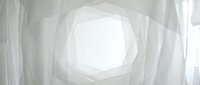 Abstract white geometric tunnel with layered polygonal walls converging toward bright central light, suitable for backgrounds, web design, and modern digital projects.