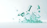 Shattered glass cosmetic bottle with splashing turquoise liquid and fragments against white background, creating dynamic freeze-motion effect.
