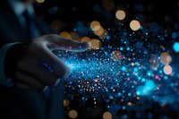 Magical glowing blue particles floating from hand against dark background with bokeh lights, creating mystical atmosphere for fantasy and spiritual concepts.