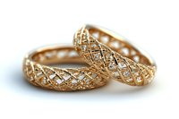 Pair of golden textured wedding bands with intricate lattice pattern design, isolated on white background, suitable for jewelry marketing, wedding invitations, and e-commerce product displays.