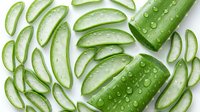 Fresh cucumber slices and whole cucumbers with water droplets arranged on white background, suitable for food, wellness, and culinary design projects.