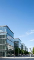 Modern glass office buildings with contemporary architecture and blue sky background for corporate business and commercial real estate concepts.