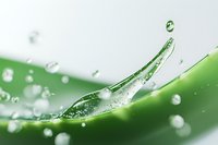 Fresh aloe vera leaf with water drops and splash on green background, extreme macro photography showing natural moisturizing properties in cosmetics.