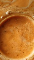 Fresh espresso coffee with golden crema and tiny bubbles in macro shot, showing rich texture and aromatic foam surface for cafe and restaurant menus.