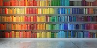 Colorful rainbow bookshelf arrangement in library interior with spectrum of books from red to blue, organized by color on wooden shelves against concrete floor.