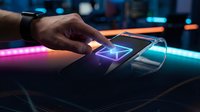 Unrecognizable person touching holographic pyramid interface on futuristic device with neon lighting, representing technology innovation and digital interaction for business applications.