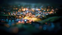 Aerial cityscape with tilt-shift effect showing illuminated bridge and urban lights creating magical bokeh effect at night, dreamy miniature look with selective focus.