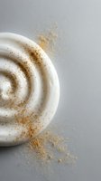 Creamy white swirl with golden spice powder dusting on neutral background for culinary and food styling projects.