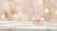 Glass flask with pink heart floating inside on white surface against soft bokeh background for romantic chemistry and love potion concepts.
