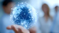 Digital network sphere floating above business person's hand showing global connectivity and data visualization in modern office environment.