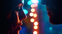 Dramatic silhouette profile of couple facing each other against blurred bokeh lights background in neon blue and orange tones, creating romantic atmosphere.