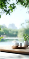Serene minimalist composition with white ceramic vessels and bamboo plant on wooden tray against blurred natural background, creating zen atmosphere for spa and wellness.