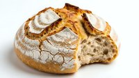 Artisan sourdough bread loaf with golden crust and airy crumb texture, freshly baked bakery product isolated on white background for culinary designs.