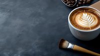 Aromatic cappuccino with latte art leaf pattern in white cup on dark background with coffee beans and brush, moody atmosphere for cafe and coffee shop menu.