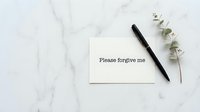 Please forgive me note card on marble surface with black pen and eucalyptus branch, flat lay apology concept.