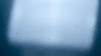 Water droplets on frosted glass surface creating abstract blue texture with condensation patterns for modern design backgrounds.