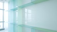 Modern minimalist interior with empty glass shelves and natural light from large windows, suitable for product display, retail design, and contemporary home decor projects.