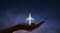 Open palm holding glowing airplane with magical light effects against dark blue night sky background for travel and aviation concepts.